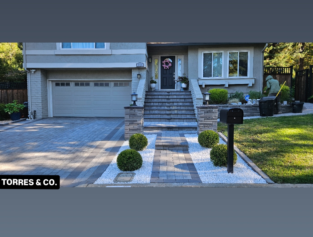 Vista del patio después de la instalación de césped artificial y adoquines.